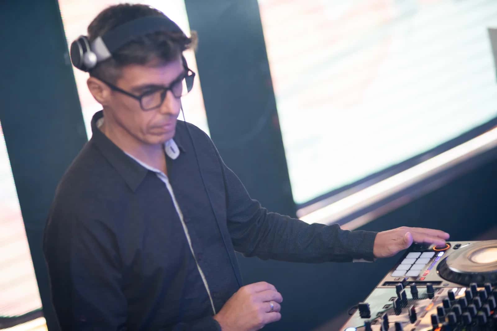 DJ BetoBrizz de fones de ouvido ajustando a controladora