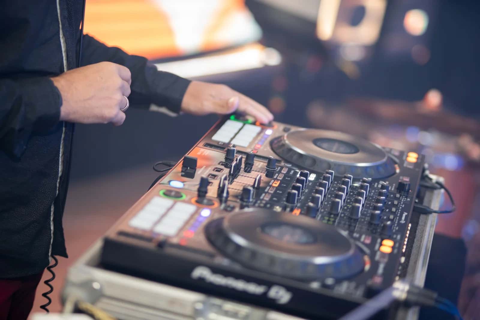 Mãos de DJ BetoBrizz mixando em uma controladora Pioneer