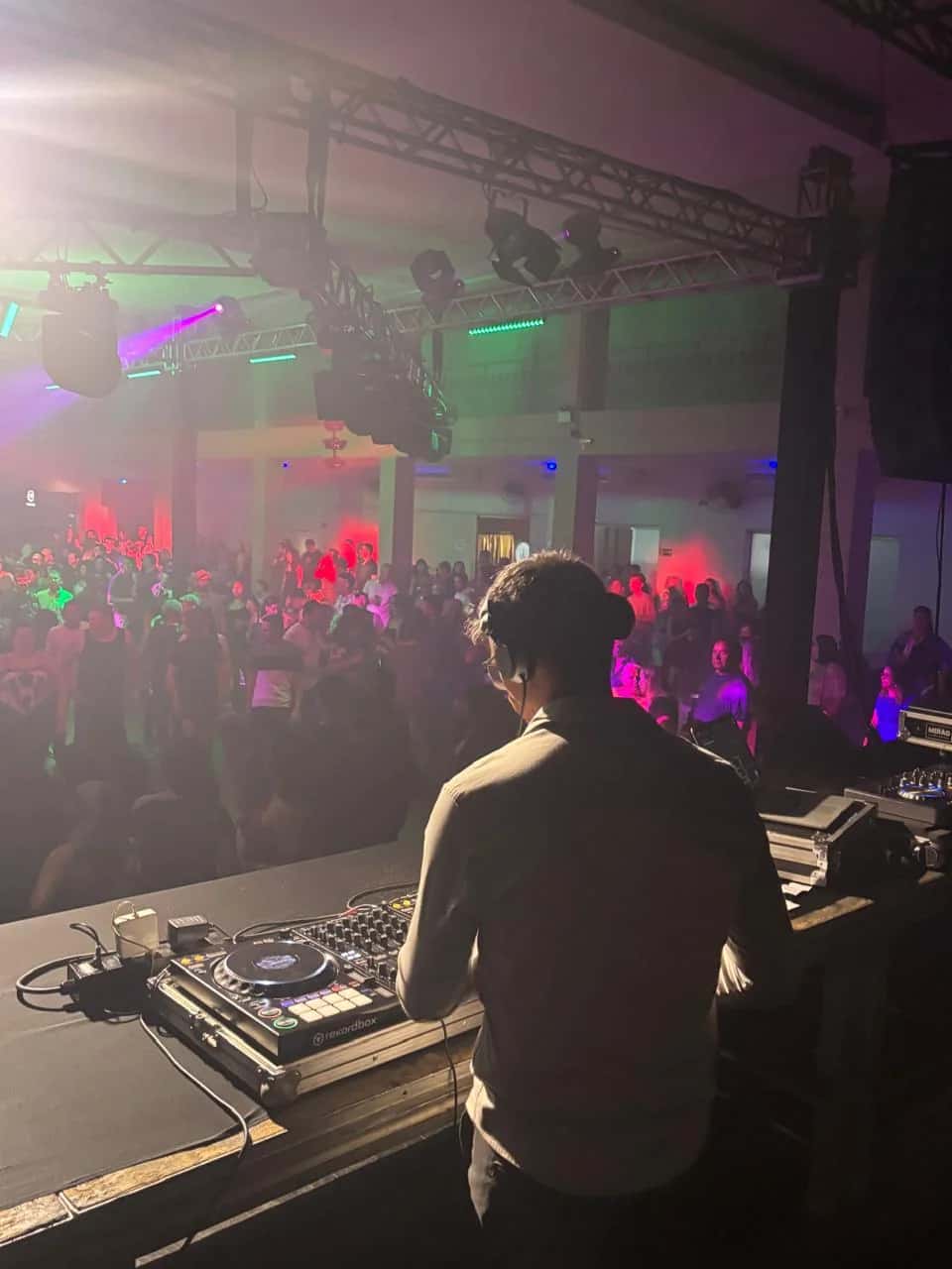 DJ BetoBrizz se apresentando ao vivo diante de telões de LED